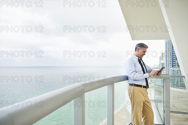 Caucasian businessman using digital tablet on balcony