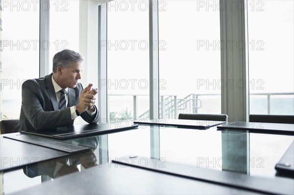 Caucasian businessman sitting at empty conference table