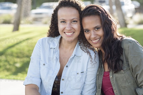 Close up of smiling women hugging in park