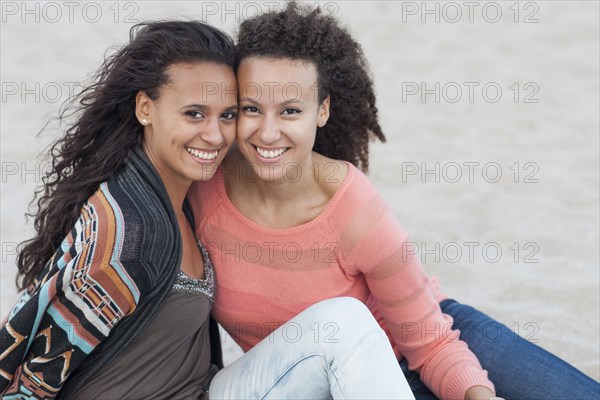 Smiling women hugging on beach