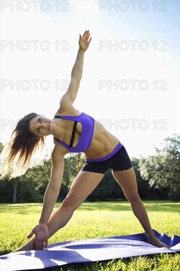 Caucasian athlete practicing yoga in park