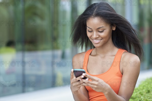 Black woman using cell phone outdoors