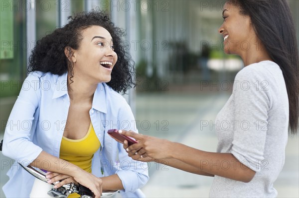 Black women talking on sidewalk