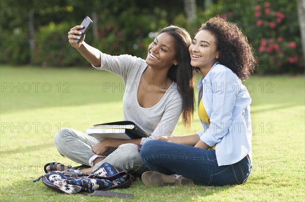 Black women taking selfie in park