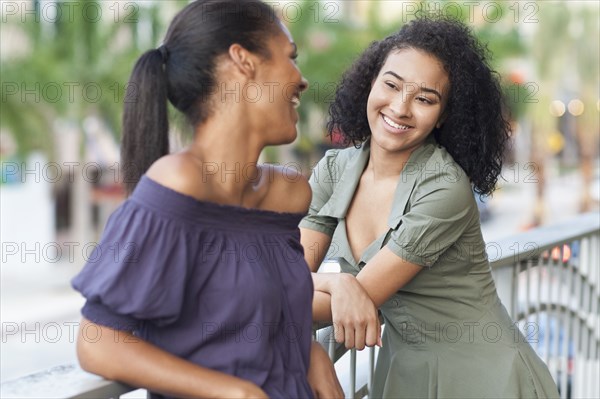 Black woman talking on balcony outdoors