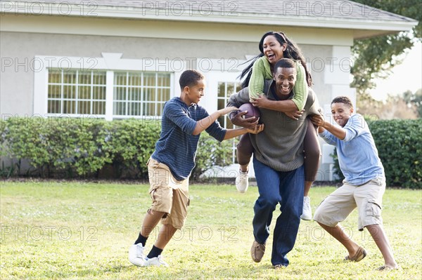 Family playing football in backyard