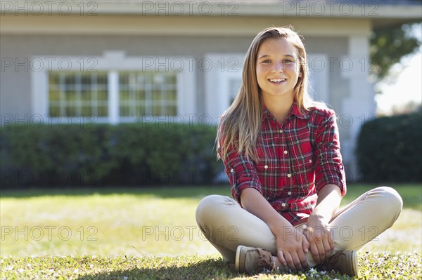 Caucasian girl sitting in backyard