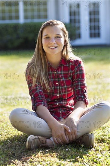 Caucasian girl sitting in backyard