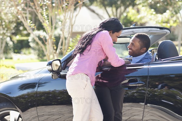 Couple hugging in convertible