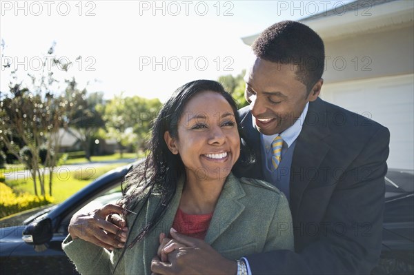 Couple hugging near convertible