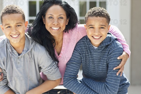 Close up of mother hugging sons outdoors