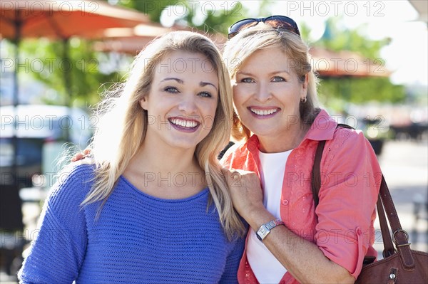 Caucasian mother and daughter smiling outdoors