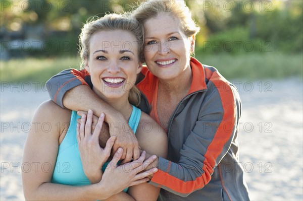 Caucasian mother and daughter hugging outdoors