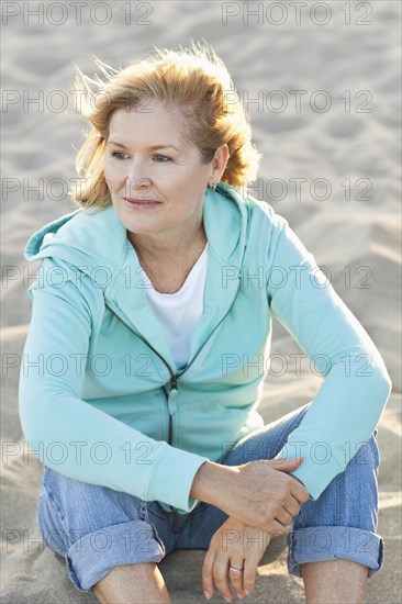 Caucasian woman sitting on beach