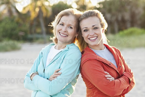 Caucasian mother and daughter standing on beach