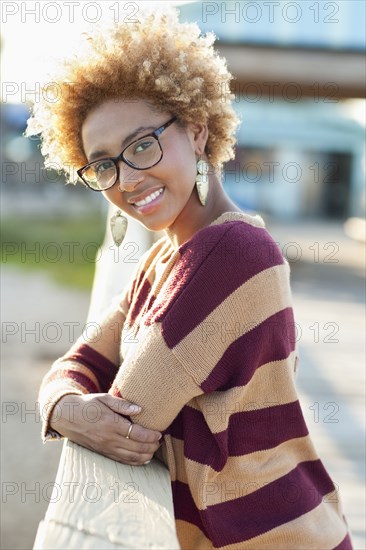 Black woman leaning on fence outdoors