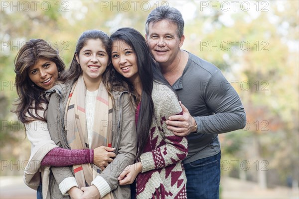 Hispanic family hugging outdoors