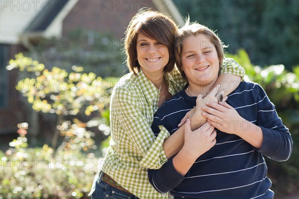 Caucasian mother and son hugging outdoors