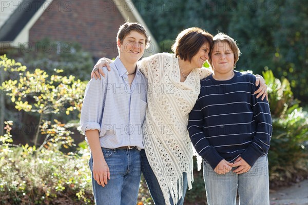 Caucasian mother and sons hugging outdoors