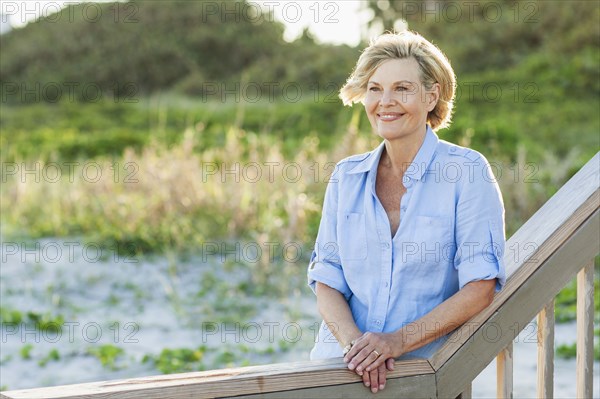 Smiling Caucasian woman standing on beach