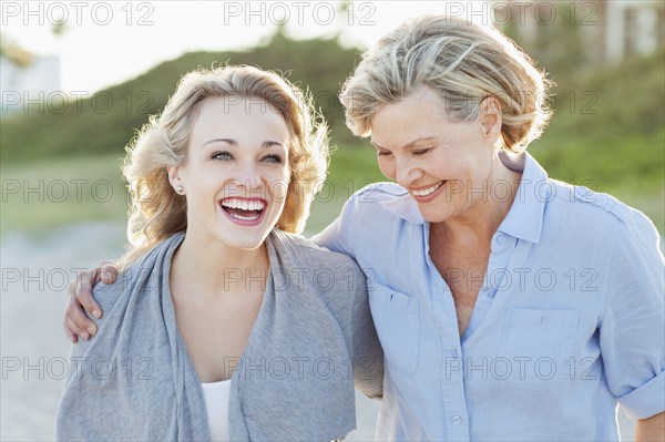 Caucasian mother and daughter hugging on beach