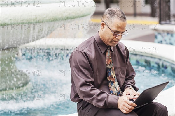 African American businessman working at fountain