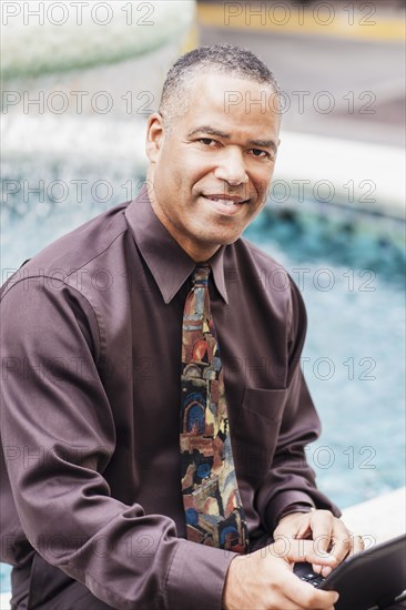 African American businessman working at fountain