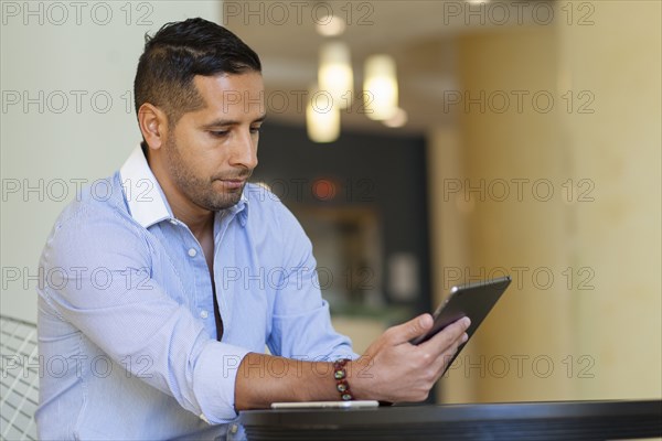 Hispanic man using digital tablet