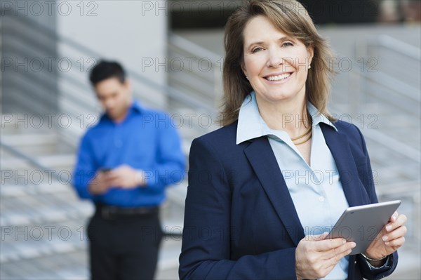 Businesswoman using digital tablet near staircase