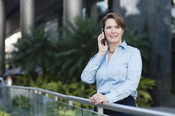 Caucasian businesswoman talking on cell phone outdoors