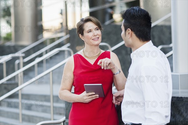 Business people using digital tablet near staircase