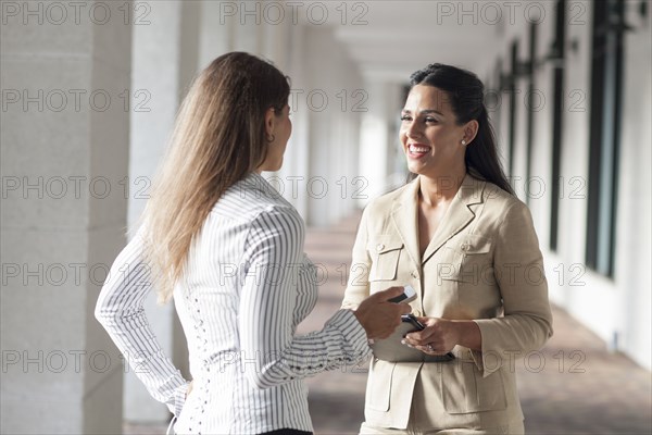 Businesswomen talking in hallway