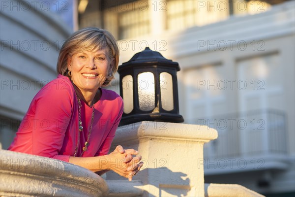 Caucasian woman leaning over balcony