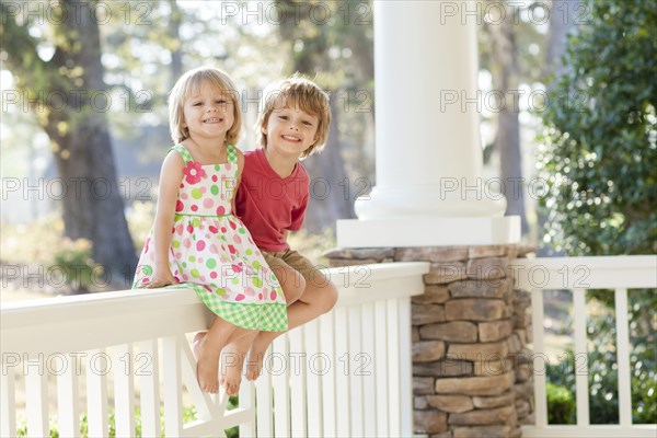 Caucasian brother and sister smiling on patio