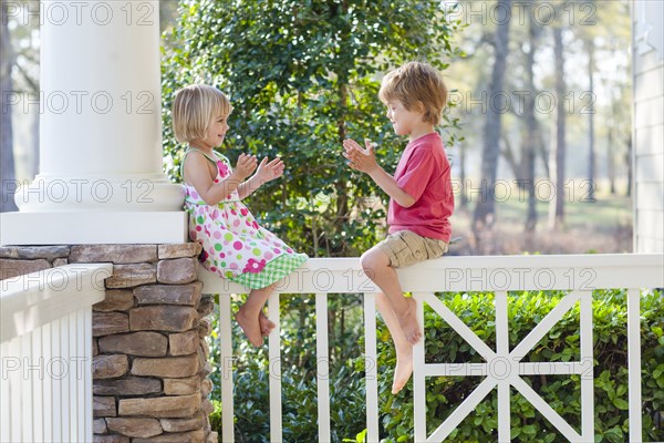 Caucasian brother and sister playing on patio