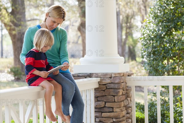 Caucasian mother and son talking on patio