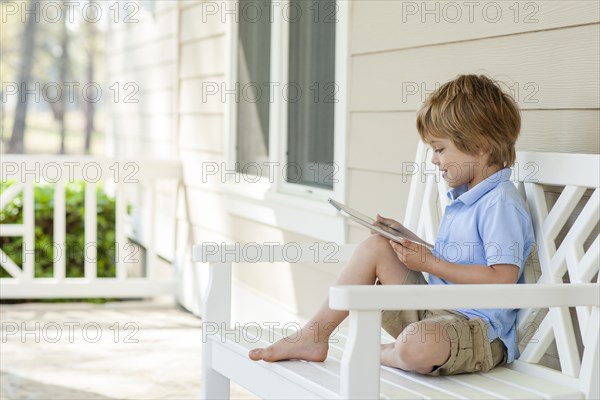 Caucasian boy using digital tablet on patio