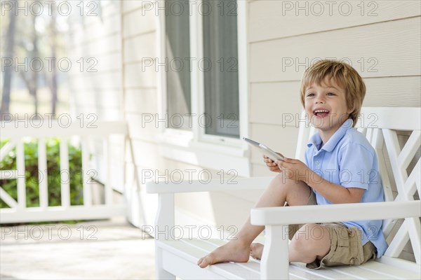 Caucasian boy using digital tablet on patio