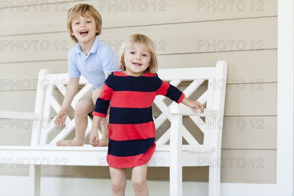 Caucasian brother and sister playing on patio