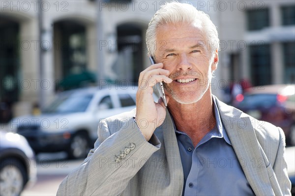 Caucasian businessman talking on cell phone in city