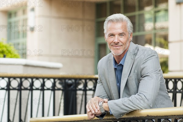 Caucasian businessman leaning over banister