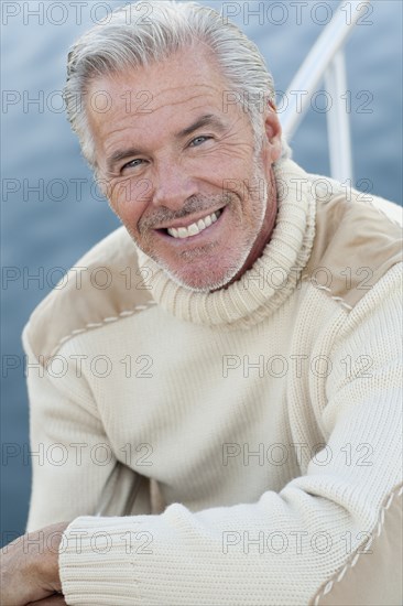 Close up of smiling Caucasian man on boat deck