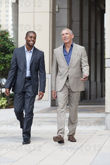 Businessmen talking on city sidewalk