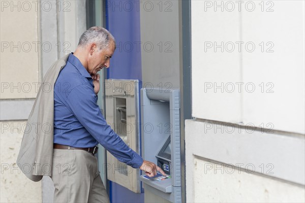 Caucasian businessman using ATM