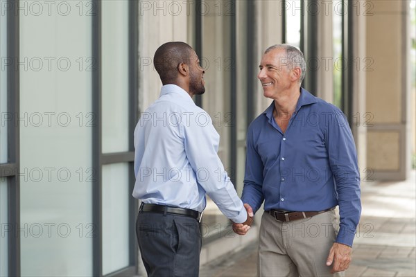 Businessmen shaking hands in city