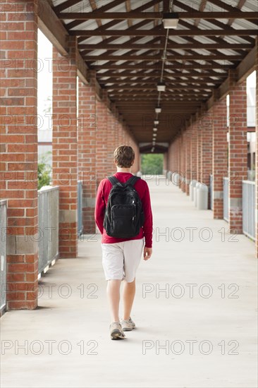 Caucasian teenage boy walking on school campus