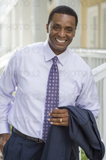 Smiling Black businessman standing outdoors