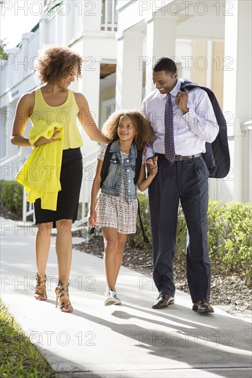 Parents walking daughter to school