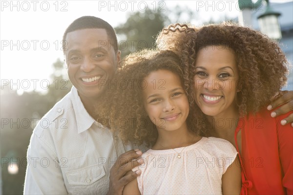 Smiling family standing outdoors