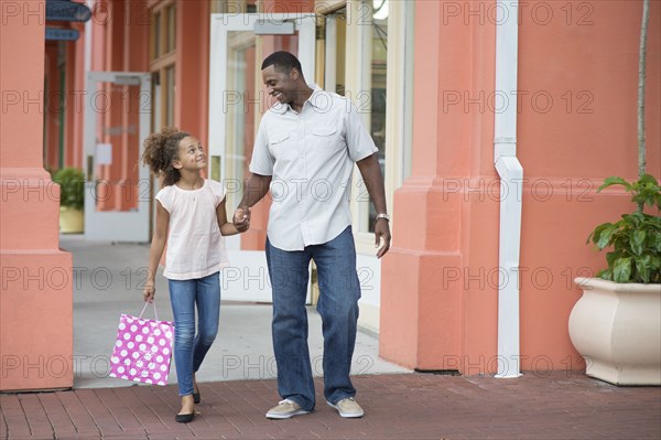 Father and daughter holding hands outdoors